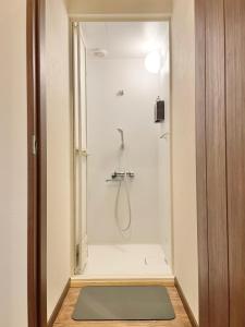 um chuveiro na casa de banho com um tapete verde em YUKARA LEAF LODGE em Nanae