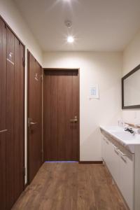 bagno con lavandino, servizi igienici e specchio di YUKARA LEAF LODGE a Nanae