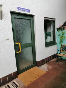 una puerta verde con un mango amarillo en un edificio en Haus Mohr - Ferienwohnung im Taunus, en Weilmünster