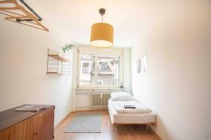 Modern 3-bedroom apartment in city centre في بازل: غرفة معيشة مع أريكة ونافذة