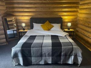 ein Schlafzimmer mit einem Bett in einem Blockhaus in der Unterkunft Вілла Розмарія in Jaremtsche