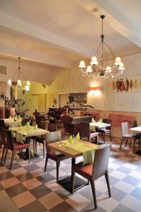 restauracja ze stołami i krzesłami oraz podłogą wyłożoną szachownicą w obiekcie HOTEL RESTAURANT CORTIE w mieście Thuir