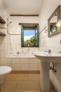 a bathroom with a sink and a tub and a window at Villas Orbani by Istarski Dvori in Sveti Lovreč Pazenatički
