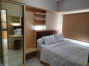 a bedroom with a large bed and a mirror at Educity 2 Bedroom by Marco H10 Wifi in Surabaya