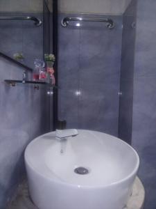 een witte wastafel in een badkamer met een douche bij Sunrise City Palace in Negombo