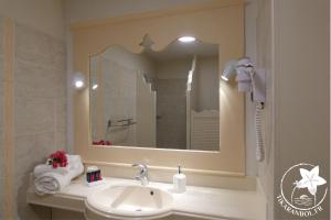 La salle de bains est pourvue d'un lavabo et d'un miroir. dans l'établissement Studio Ti Karanbol RDC vue mer dans Résidence de Tourisme, à Sainte-Anne