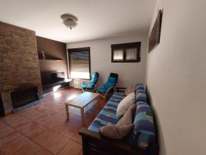 een woonkamer met een bank en een open haard bij La Atalaya de Villalba in Cuenca