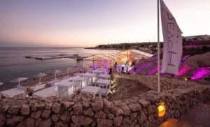 eine Hochzeit am Strand mit weißen Tischen und Stühlen in der Unterkunft Suite esclusiva Domina Coral Bay Resort Spa & Casino in Sharm El Sheikh