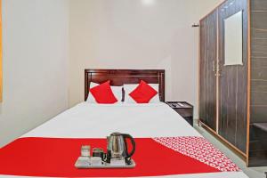 a bedroom with a bed with red pillows at Super OYO Mn Residency Near Ragigudda Sri Prasanna Anjaneyaswamy Temple in Bangalore