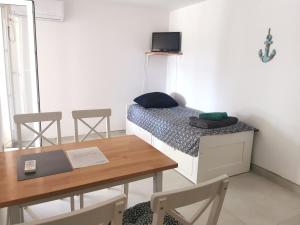 a small room with a bed and a table and chairs at Apartments Silver in Novalja
