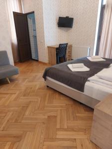 1 dormitorio con 1 cama y suelo de madera en Eco Oasis, en Surami