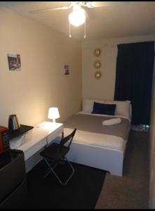 1 dormitorio con 1 cama y escritorio con lámpara en Avalon Stay 7 nights minimum booking, en Jacksonville