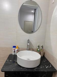 y baño con lavabo blanco y espejo. en An Chi Homestay en Hue
