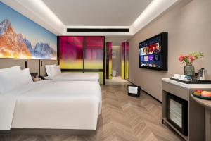 Postel nebo postele na pokoji v ubytování Echarm PLUS International Hotel Zhujiang New Town Wuyangcun Metro Station Branch- Free Deliver Service to Canton Fair Complex During Canton Fair Period