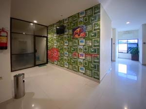 um corredor com uma parede coberta de azulejos em Hotel Alpha Makassar RedPartner em Makassar