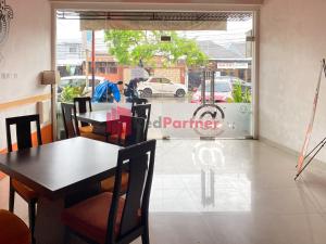 ein Esszimmer mit Tischen, Stühlen und einem Fenster in der Unterkunft Hotel Alpha Makassar RedPartner in Makassar