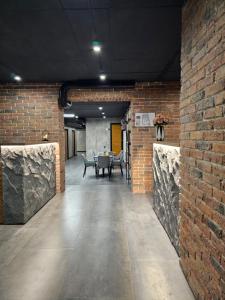 Cette chambre est dotée d'un mur en briques et d'une table. dans l'établissement Orion Hostel, à Erevan