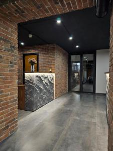 une pièce vide avec un mur en briques et un comptoir en pierre dans l'établissement Orion Hostel, à Erevan