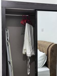 a closet with red hangers and white clothes at Studio Homestay in Sungai Buluh