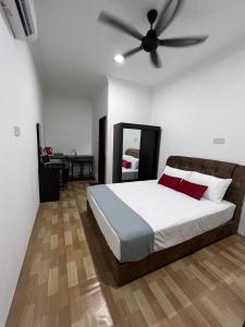 a bedroom with a bed with a ceiling fan at Studio Homestay in Sungai Buluh