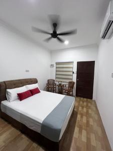 a bedroom with a bed and a ceiling fan at Studio Homestay in Sungai Buluh