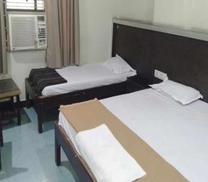 a bedroom with two beds and a window at iROOMZ Hoysala Residency in Bellary