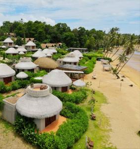 a group of buildings with roofs on a beach at The Mak Trat in Ko Mak