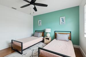 two beds in a room with a ceiling fan at Amazing 2 Bedroom Townhouse near beach in Indialantic