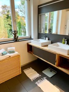a bathroom with two sinks and a large mirror at Gästehaus Casa Cecilia in Wetzikon