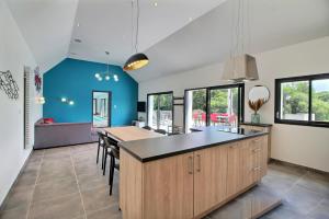 een keuken met blauwe muren en een tafel met stoelen bij Longère avec piscine intérieure, spa, sauna in Douarnenez
