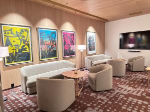 un soggiorno con divani, sedie e dipinti di Scandic Parken ad Ålesund