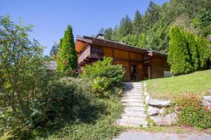 a house on a hill with stairs in front of it at Chalet Résidence Chantey Mourry 67 - Happy Rentals in Chamonix-Mont-Blanc