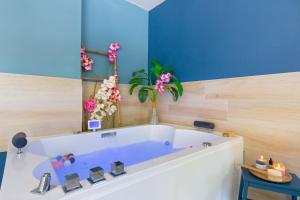 a bathroom with a tub with flowers in it at Appartement jacuzzi 4 étoiles - Love Room Beauté in Puget-sur Argens