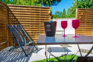 a table with two wine glasses and a bucket on it at Appartement jacuzzi 4 étoiles - Love Room Beauté in Puget-sur Argens
