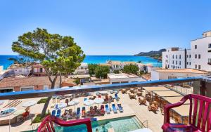 een balkon met uitzicht op een resort met een zwembad bij Hotel Clumba in Cala Ratjada