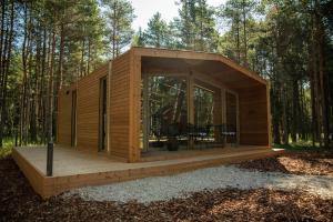 a tiny house in the woods with a deck at Roosta Holiday Village in Elbiku