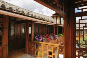 een balkon van een huis met bloemen erop bij Saturday Inn in Lijiang