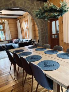 una gran mesa de madera con sillas en una habitación en Odskocznia House en Szczyrk