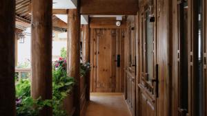 a hallway in a house with wooden walls and plants at Xilu Saturday Smart Vacation Garden in Lijiang