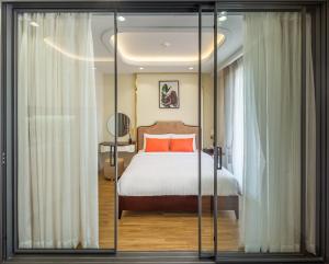 ホーチミン・シティにあるSimmi Apartment Phu My Hungのベッドルーム1室(オレンジ色の枕が付いたベッド1台付)