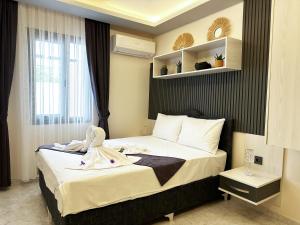 a bedroom with a bed with a robe on it at Marina Lora Butik Otel in Seferihisar