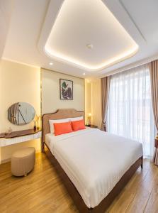a bedroom with a large bed with orange pillows at Simmi Apartment Phu My Hung in Ho Chi Minh City