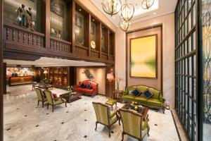 a lobby with chairs and tables in a building at Lucien Hanoi Lakeside Hotel & Rooftop in Hanoi +37 photos