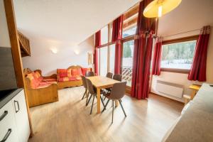 a living room with a table and chairs and a couch at Résidence Capfun du Téléphérique, Morzine in Morzine
