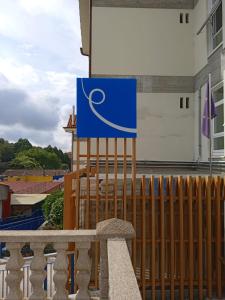 una señal azul en una valla al lado de un edificio en Loop INN Hostel Santiago de Compostela, en Santiago de Compostela