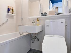 Łazienka z białą toaletą i umywalką w obiekcie Vessel Hotel Campana Susukino w mieście Sapporo