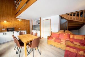 a living room with a table and a couch at Résidence Capfun du Téléphérique, Morzine in Morzine