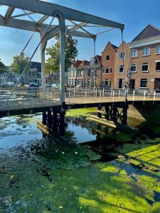 een brug over een waterlichaam met gebouwen bij Studio 157, in de stad aan de gracht in Kampen