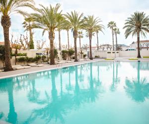 a swimming pool with palm trees in a resort at Kiko Park Oliva in Oliva