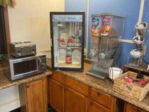 a kitchen counter with a refrigerator and a microwave at Budget Host Inn in Buffalo